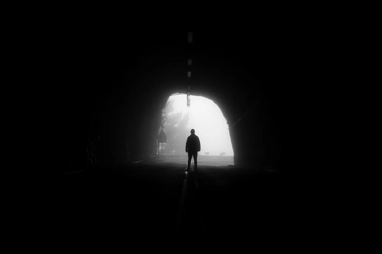 Silueta d’una persona davant de la sortida il·luminada d’un túnel.